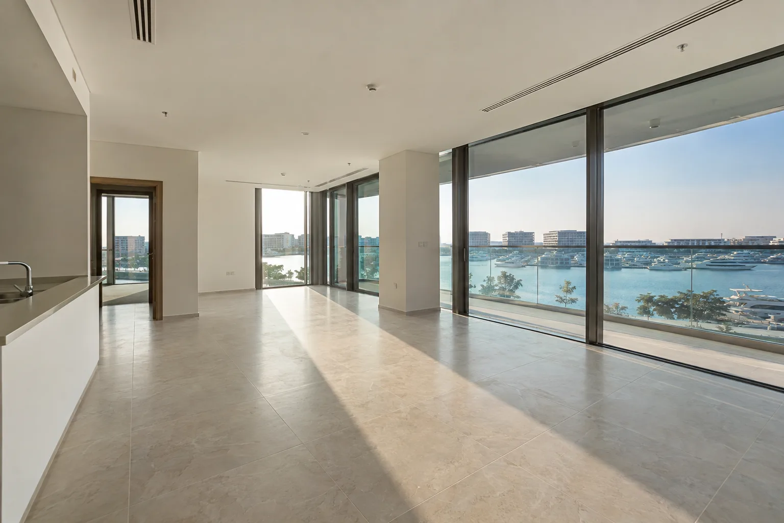 Bright living room of a roughly 1,200 sq ft apartment on Yas, floor-to-ceiling windows and balcony overlooking the marina