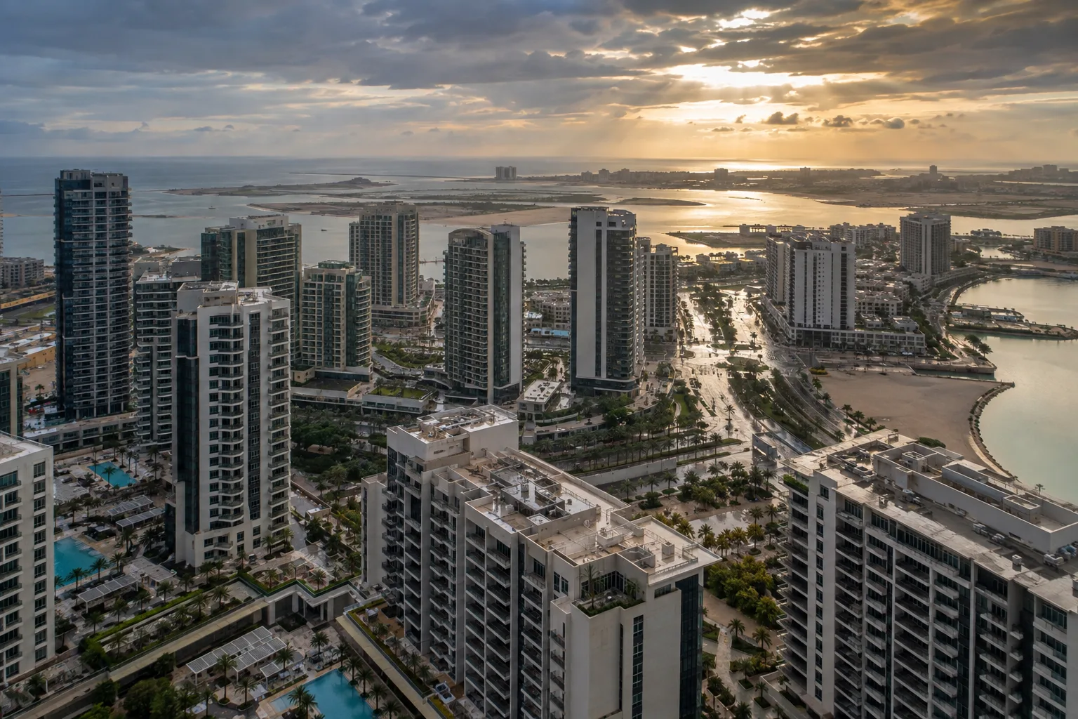 Oblique aerial view of Reem Island's residential towers after rain, with Saadiyat in the distance