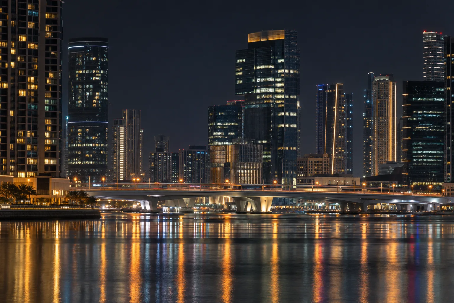 Channel between Al Reem and Al Maryah at night, illuminated office towers and a road bridge with light trails