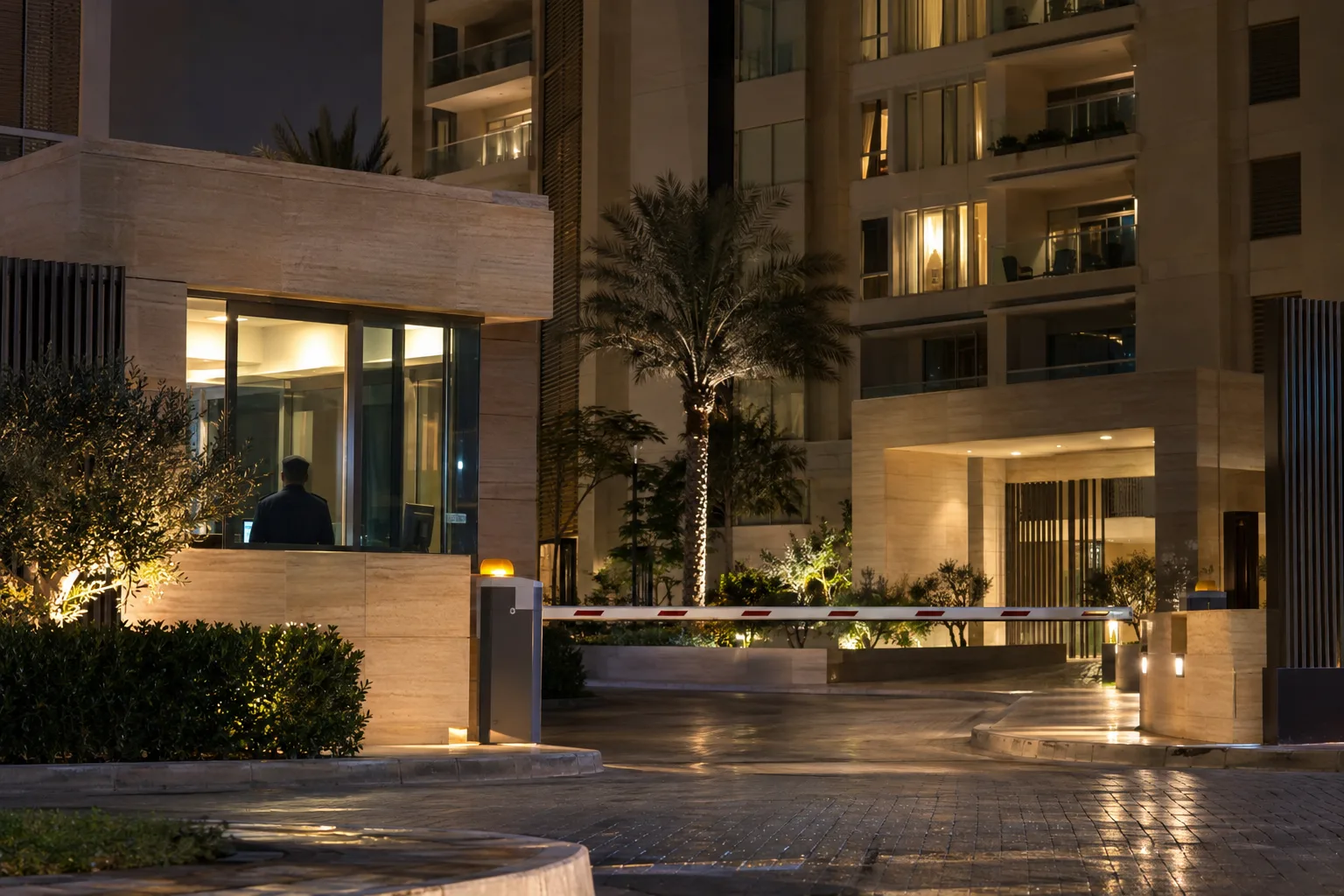 Secure, lit entrance of an Abu Dhabi residence at night, with the silhouette of a security guard