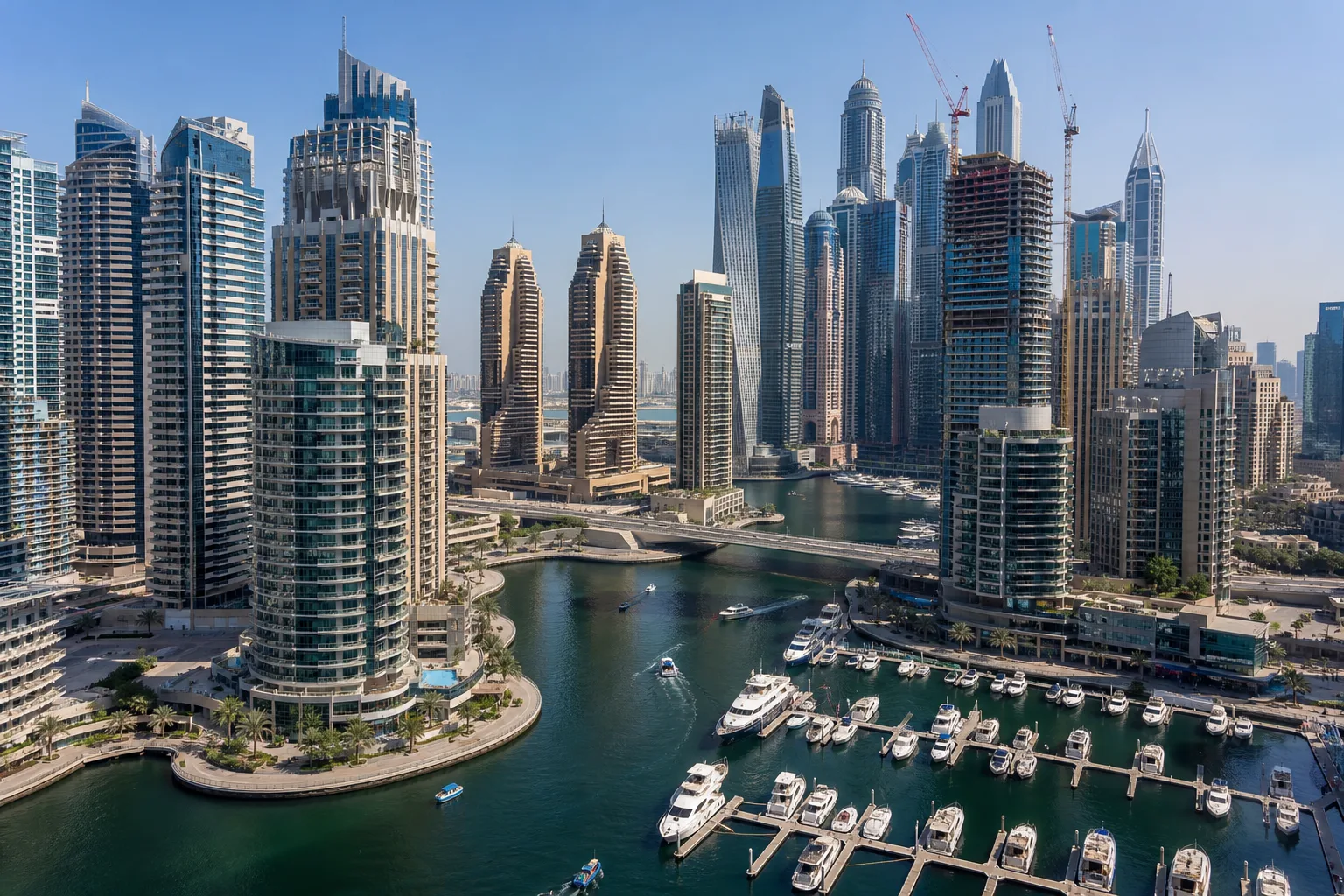 Aerial view of Dubai Marina with its residential towers lined along the canal and yachts moored at the foot of the buildings
