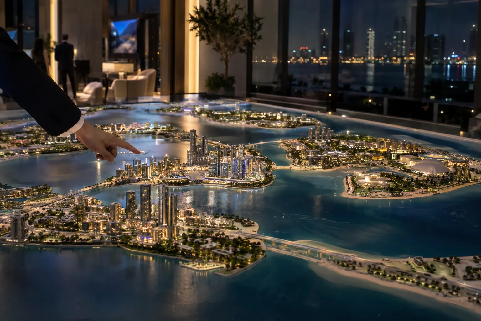 Illuminated scale model of Abu Dhabi's islands in a sales gallery, a visitor's hand pointing to a district