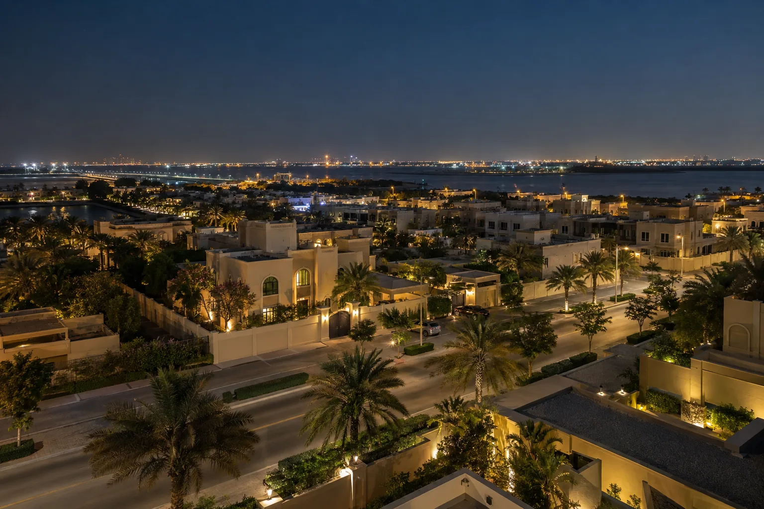 Al Bahyah villa district at night, lit streets and palm trees between walled houses