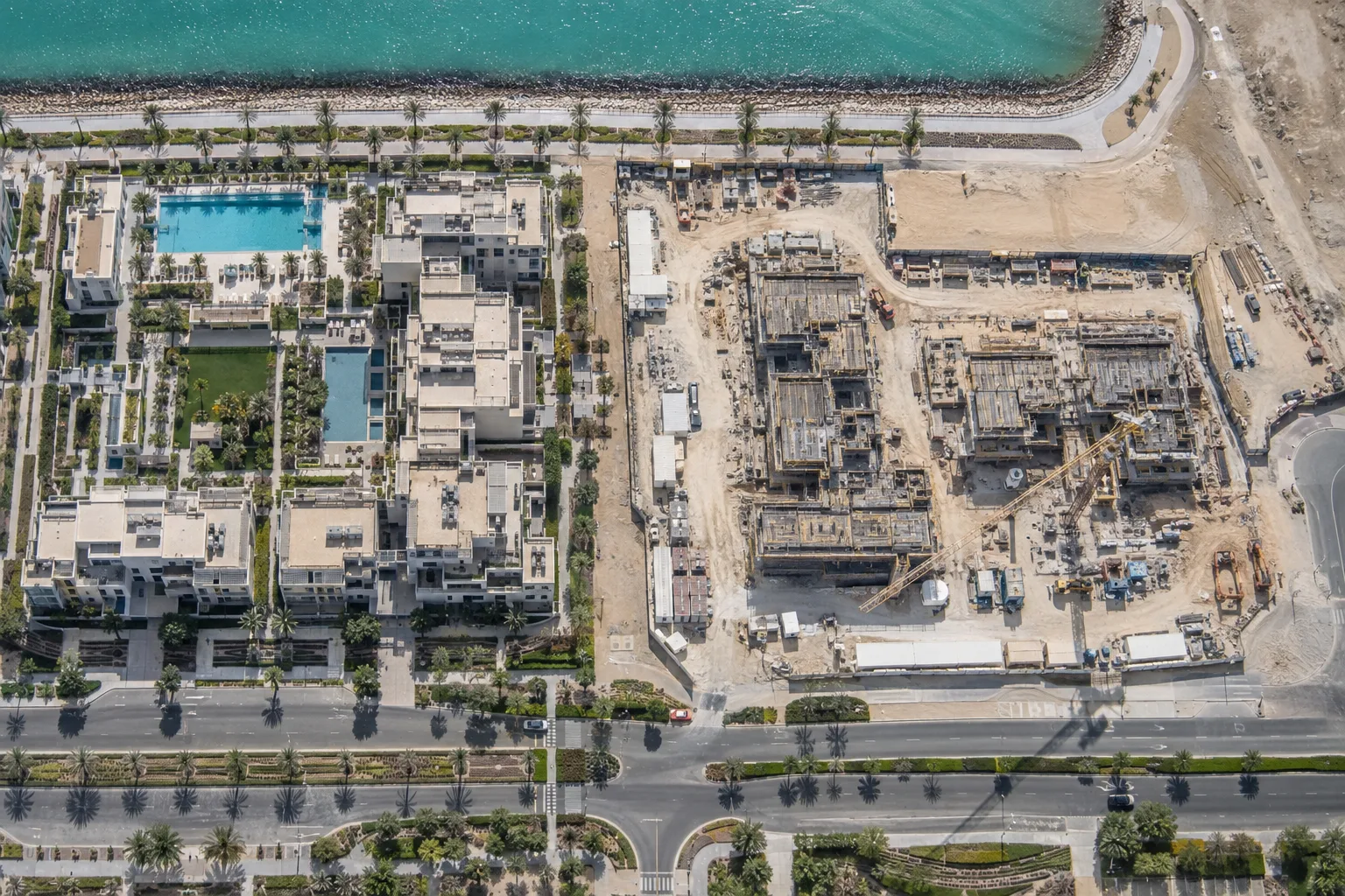 Overhead view of a completed residence next to a site at foundation stage on Yas Island