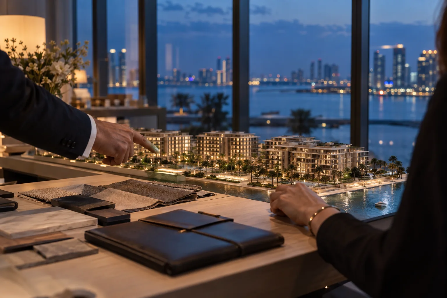 Hands of an investor and an advisor over a scale model of an off-plan project, with material samples