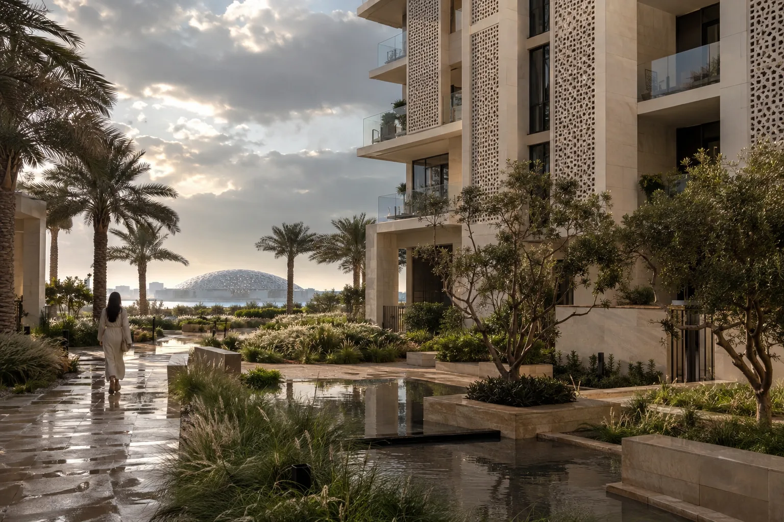 Landscaped garden wet after the rain at the foot of a light-stone residential building in the Saadiyat cultural district