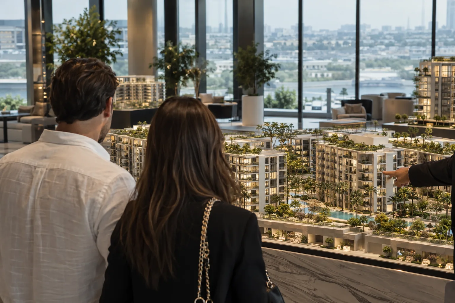 Buyers seen from behind in front of a residential development model in an off-plan sales gallery in Dubai