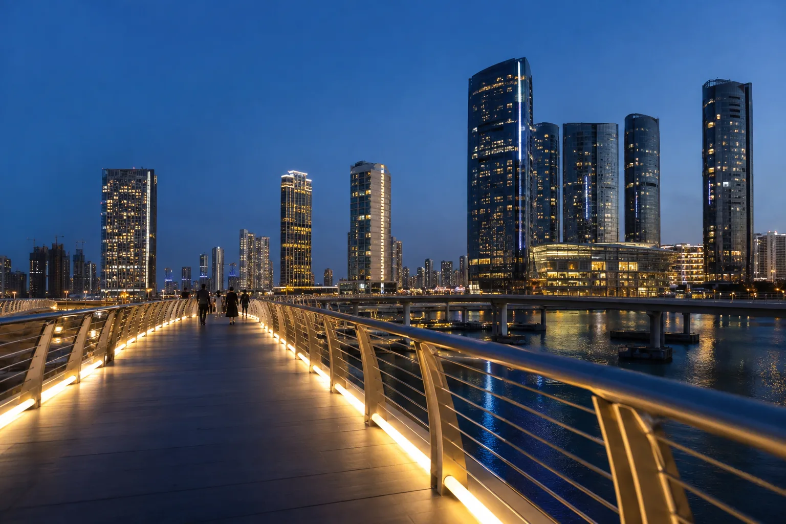 Illuminated footbridge linking Reem Island to Al Maryah Island at blue hour, silhouettes of passers-by