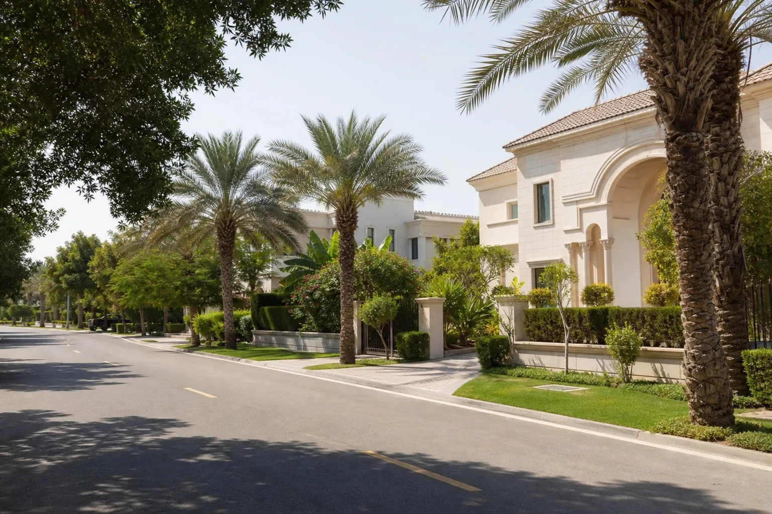 Avenida residencial arbolada de Emirates Hills con villas de fachadas majestuosas