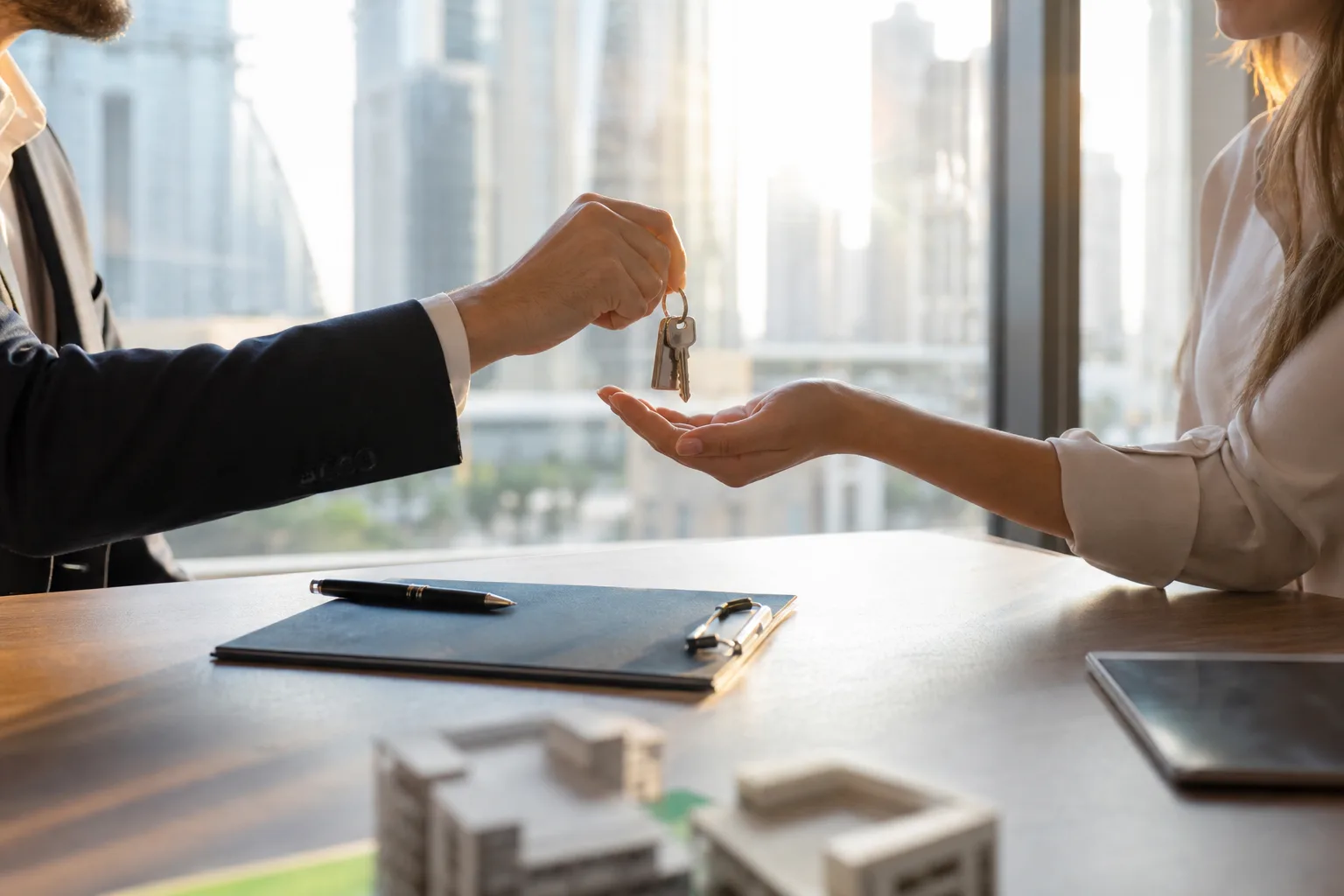 Symbolic handover of keys in a modern notary office overlooking the towers of Dubai